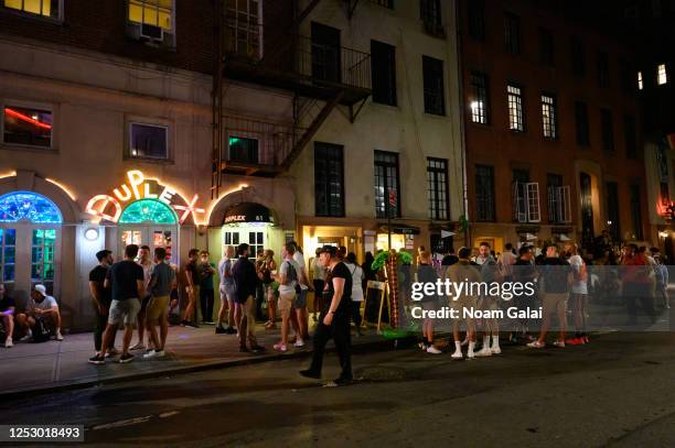 People stand outside The Duplex bar in the West Village as New York City moves into Phase 2 of re-opening following restrictions imposed to curb the...