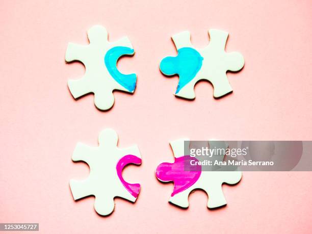 white puzzle pieces with a painted heart on a pink background - ana maria parera bildbanksfoton och bilder