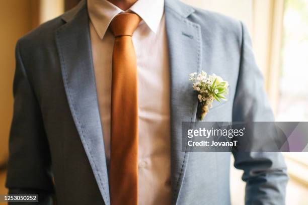 groom with flower on his blue suit - completo arancione foto e immagini stock