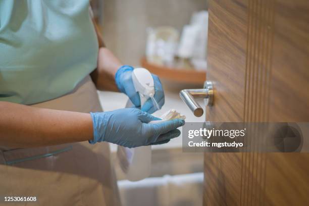 coronavirus, covid 19 protection. woman disinfects and cleans door handle with antibacterial wet wipes. - hotel bathroom stock pictures, royalty-free photos & images