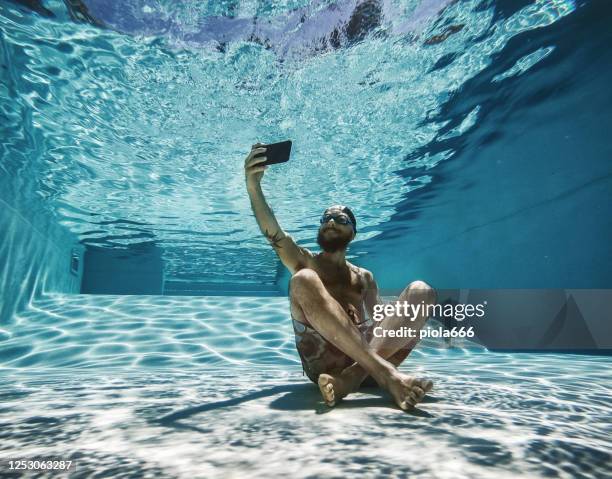 uomo maniaco del lavoro che usa il cellulare sott'acqua: dipendenza da internet - crazy pool foto e immagini stock