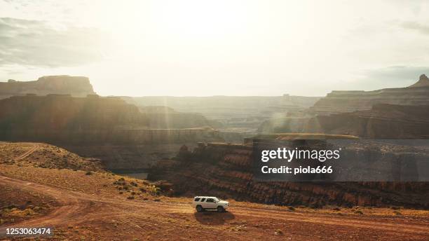 drone view: vliegen over een off-road auto op de shafer trail canyonlands - moab utah stockfoto's en -beelden