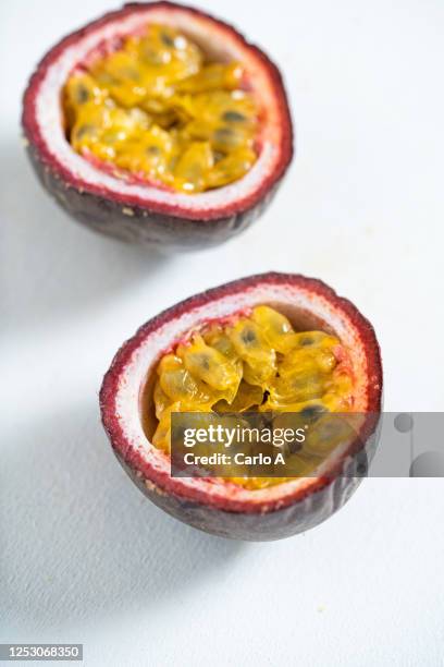 halved passionfruit on white background - passievrucht stockfoto's en -beelden