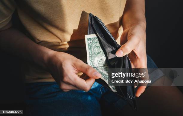 close up of hopeless woman open her empty wallet and found only one dollar bill. - wallet stock pictures, royalty-free photos & images