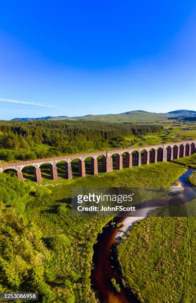 vertical panoramic aerial view of a river flowing towards a disused railway viaduct in rural dumfries and galloway, south west scotland - dumfries and galloway stock pictures, royalty-free photos & images