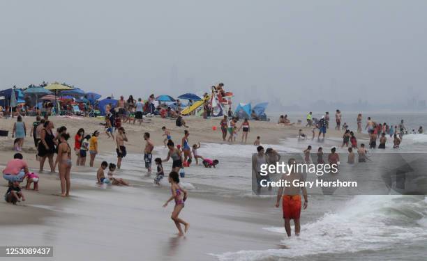 People swim in the Atlantic Ocean in front of the skyline of New York City on a beach at Sandy Hook park at the Jersey Shore on June 27, 2020 in...