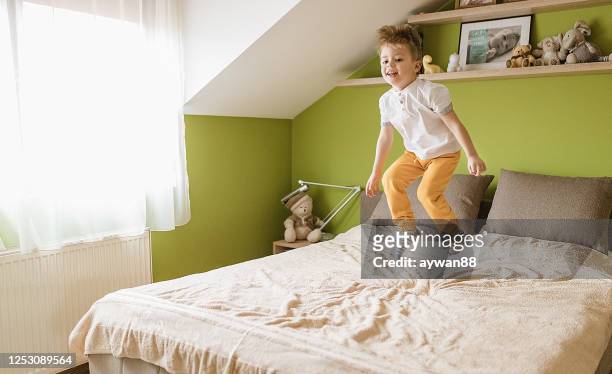 little boy jumping on the bed - a boy jumping on a bed stock pictures, royalty-free photos & images