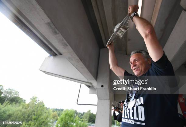Uwe Neuhaus, head coach of Bielefeld holds the second Bundesliga trophy to show the fans after the Second Bundesliga match between DSC Arminia...