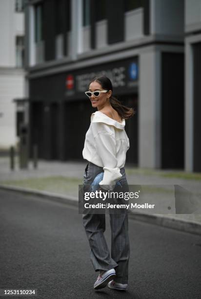 Anna Schürrle wearing Bottega Veneta bag, Alexander Wang blouse, Max Mara pants, Tiger sneaker and Celine shades on June 28, 2020 in Berlin, Germany.