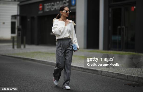 Anna Schürrle wearing Bottega Veneta bag, Alexander Wang blouse, Max Mara pants, Tiger sneaker and Celine shades on June 28, 2020 in Berlin, Germany.