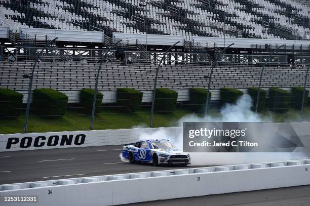 Chase Briscoe, driver of the Highpoint.com Ford, celebrates with a burnout after winning the NASCAR Xfinity Series Pocono Green 225 Recycled by J.P....