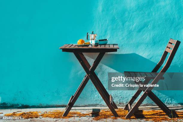 desayuno en el jardín, mesa y silla de madera , con fondo azul turquesa - mesa de madera bildbanksfoton och bilder