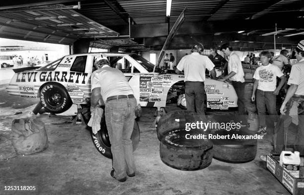 Members of NASCAR driver Geoff Bodine's crew work on Bodine's race car prior to the start of the 1986 Pepsi Firecracker 400 stock car race at Daytona...