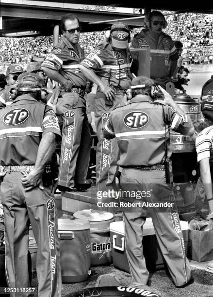 Members of NASCAR driver Richard Petty's crew wait for their car and driver to make a pit stop during the running of the 1986 Pepsi Firecracker 400...