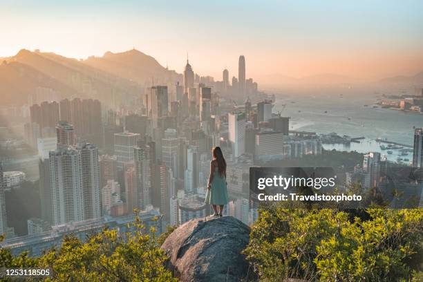 girl facing the sunset over hong kong - china cityscape stock-fotos und bilder