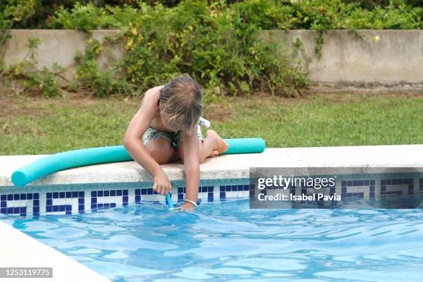 little boy taking water from pool for squirting water gun - young girls that squirt stock pictures, royalty-free photos & images