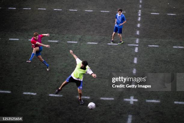 Group of men play an informal football match in a field with lines marked to keep distance on June 27, 2020 in Pergamino, Argentina. As quarantine...