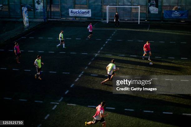 Group of men play an informal football match in a field with lines marked to keep distance on June 27, 2020 in Pergamino, Argentina. As quarantine...