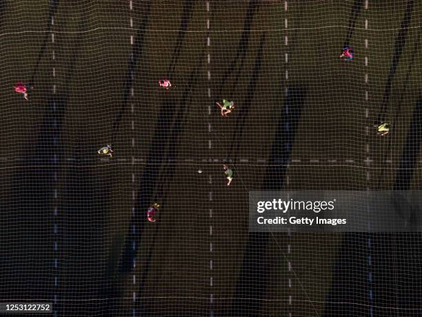 Aerial view of a group of men play an informal football match in a field with lines marked to keep distance on June 27, 2020 in Pergamino, Argentina....