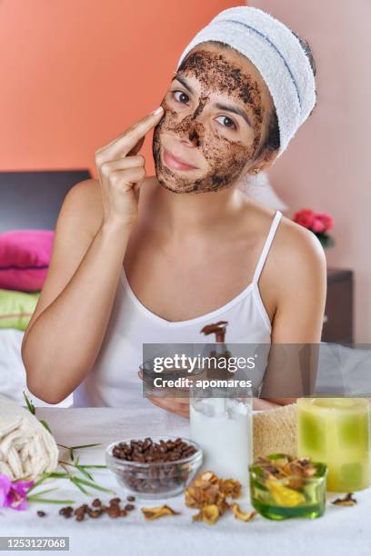 spansktalande ung kvinna med kaffe ansikte scrub i ansiktet efter bad. hudvård teman. - body scrub bildbanksfoton och bilder