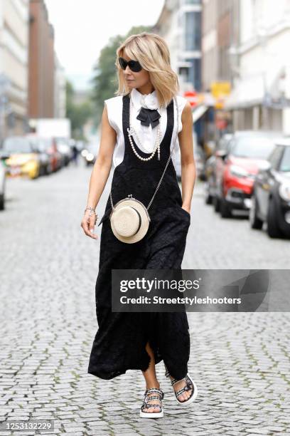 Influencer Gitta Banko wearing a black lace dress by Chanel, a black bow necklace with white camellia by Chanel, black sunglasses by Chanel, a cream...