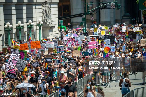 People hold signs and wave flags as they march in Lower Manhattan during the Queer Liberation March for Black Lives & Against Police Brutality on...