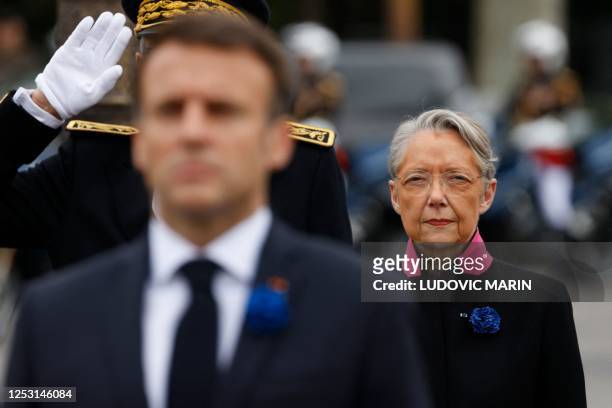 French Prime Minister Elisabeth Borne looks on as French President Emmanuel Macron pays tribute by the statue of the General de Gaulle as they attend...