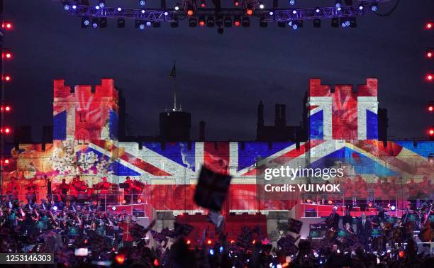 Crowds watch performers inside Windsor Castle grounds during the Coronation Concert, in Windsor, west of London on May 7, 2023. For the first time...