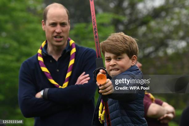 Watched by his father Prince William, Prince of Wales, Prince George of Wales tries his hand at archery while taking part in the Big Help Out, during...