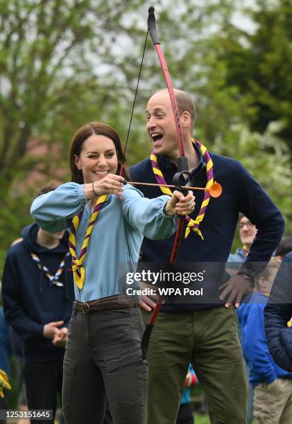 Watched by Prince William, Prince of Wales, Catherine, Princess of Wales, tries her hand at archery while taking part in the Big Help Out, during a...