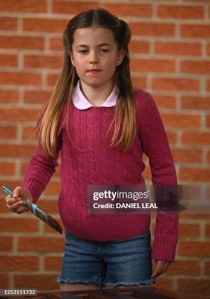 Britain's Princess Charlotte of Wales stains some wood while taking part in the Big Help Out, during a visit to the 3rd Upton Scouts Hut in Slough,...