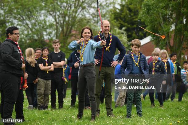 Watched by Britain's Prince William, Prince of Wales and Britain's Prince George of Wales , Britain's Catherine, Princess of Wales, tries her hand at...