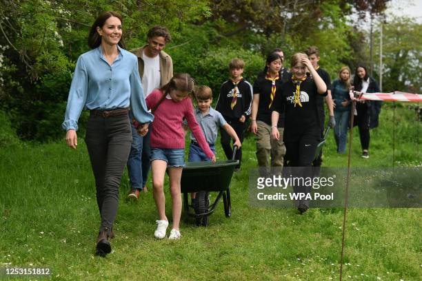 Britain's Prince Louis of Wales pushes a wheelbarrow as he follows his mother, Britain's Catherine, Princess of Wales and sister Britain's Princess...