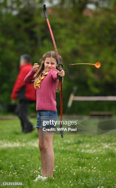 Britain's Princess Charlotte of Wales tries her hand at archery while taking part in the Big Help Out, during a visit to the 3rd Upton Scouts Hut in...