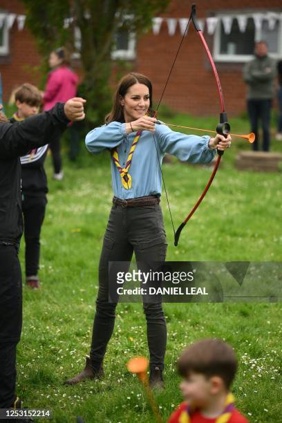 Britain's Catherine, Princess of Wales, tries her hand at archery while taking part in the Big Help Out, during a visit to the 3rd Upton Scouts Hut...