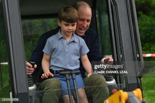 Britain's Prince William, Prince of Wales is helped by Britain's Prince Louis of Wales as he uses an excavator while taking part in the Big Help Out,...