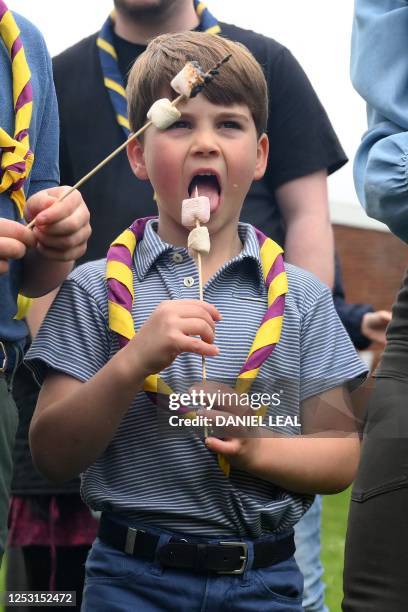 Britain's Prince Louis of Wales enjoys a toasted marshmallow as he takes part in the Big Help Out, during a visit to the 3rd Upton Scouts Hut in...