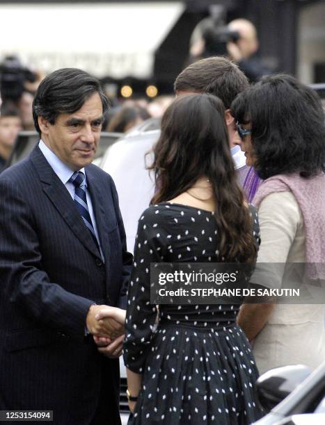 French Prime Minister Francois Fillon comforts Nathalie Serrault and Gwendoline Courreges , daughter and grand-daughter of French actor Michel...