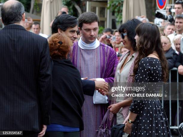 French Prime Minister Francois Fillon comforts Nathalie Serrault and Gwendoline Courreges , daughter and grand-daughter of French actor Michel...