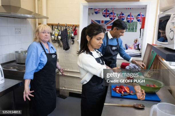 Britain's Prime Minister Rishi Sunak and his wife Akshata Murty help out in the kitchen as they take part in the Big Help Out, during a visit to a...