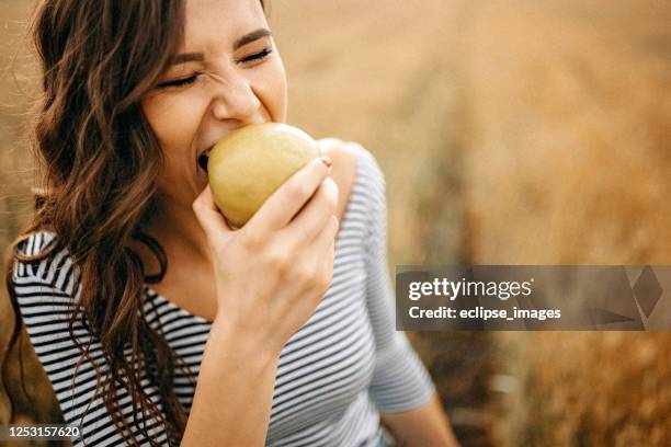 unbekümmerte frauen essen apfel - apple stock-fotos und bilder