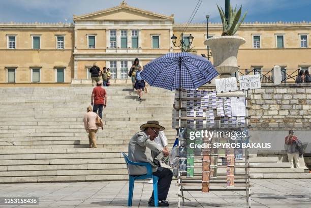 Lottery ticket seller sits in front of the Greek Parliament at Syntagma square, in Athens on May 8 ahead of the Greek general election on May 21,...