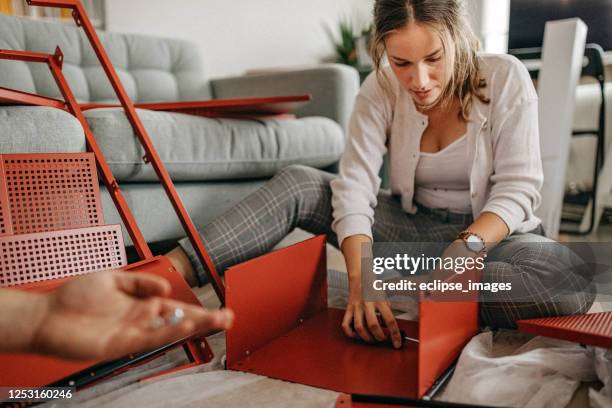 women assembling furniture - building shelves stock pictures, royalty-free photos & images