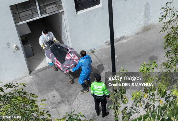 Aerial picture showing the remains of a victim of a devastating fire in a gold mine in southern Peru, being carried by morgue personnel into the...