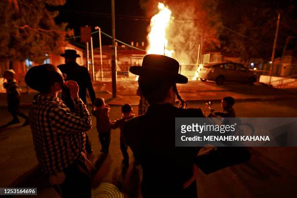 Ultra-Orthodox Jewish men and children gather around a bonfire in Jerusalem's Mea Shearim neighbourhood on May 8 as people celebrate the Jewish...