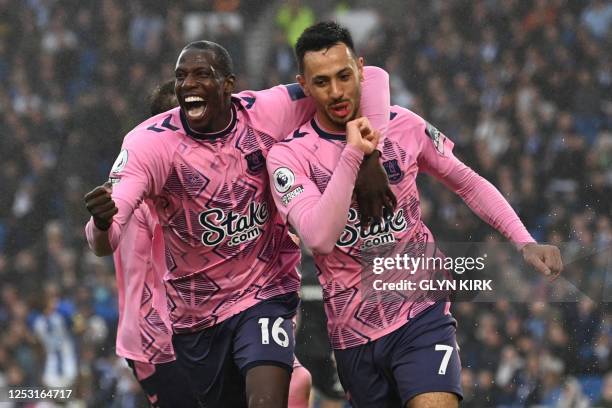 Everton's England midfielder Dwight McNeil celebrates with Everton's French midfielder Abdoulaye Doucoure after scoring their fourth goal during the...