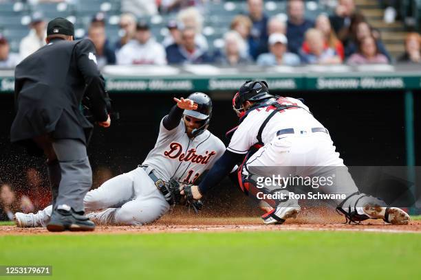 Mike Zunino of the Cleveland Guardians tags out Eric Haase of the Detroit Tigers as he attempts to score on a double by Riley Greene during the...