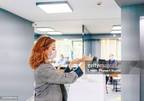 affärskvinna rengöring händer med desinfektionsmedel på kontoret - office cleaning bildbanksfoton och bilder