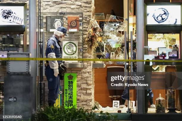 Photo taken May 8 shows police officers at Quark Ginza 888, a Rolex specialty store in Tokyo's upmarket Ginza shopping district, after wristwatches...