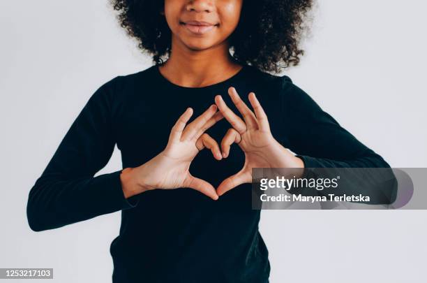 dark-skinned curly girl holding a red heart. - couple dark background stock pictures, royalty-free photos & images